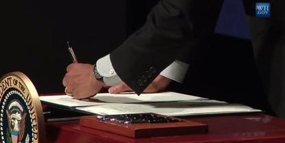 President Barack Obama signs an executive order at the Summit on Cybersecurity and Consumer Protection at Stanford University.